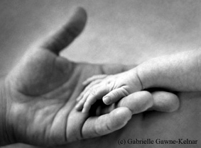 Image of baby's hand holding its parent's hand, illustrating an article on postnatal depression counselling